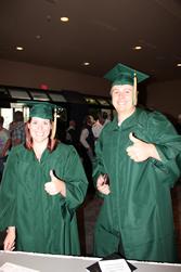 Two 澳门新甫京娱乐游戏在线下载 graduates in green caps and gowns.